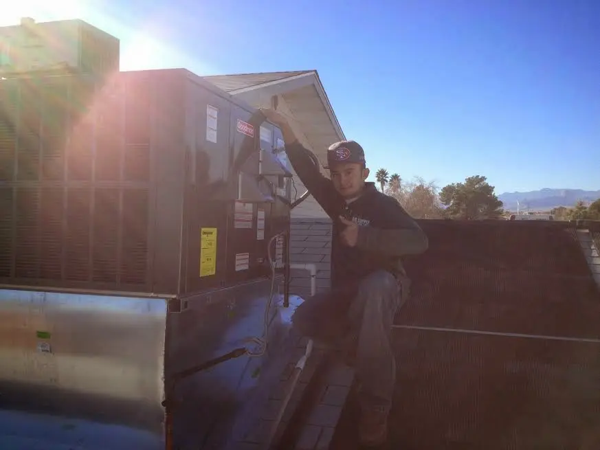HVAC technician performing AC Tune-Up on a rooftop unit in Cromwell